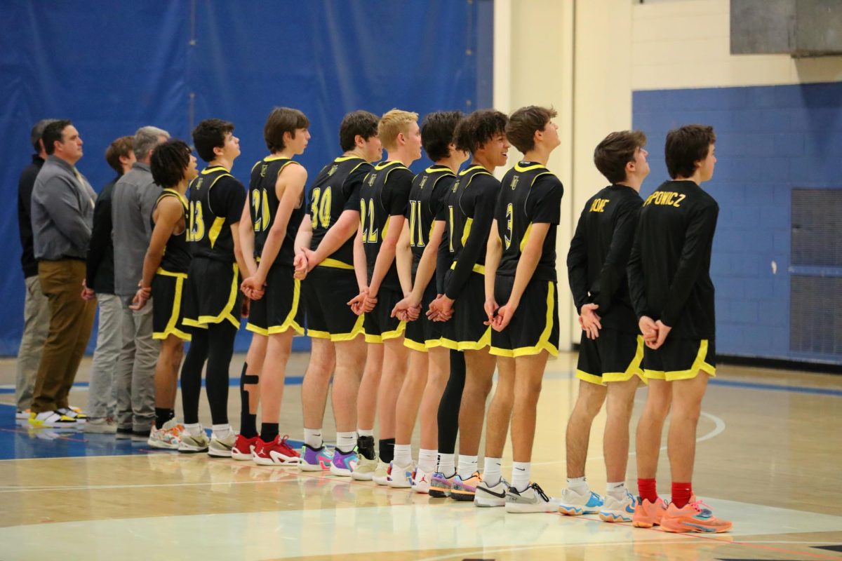 Boys basketball team line up for the anthem before their game against U-32 on December 13, 2023.